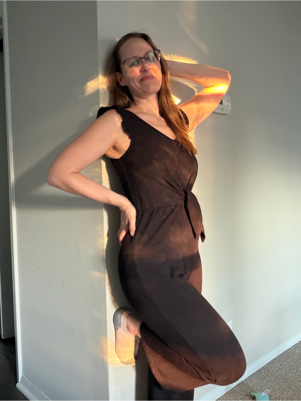 Sleeveless Black Knit Jumpsuit with Twist Front and Flutter Sleeves.
